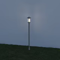 Outdoor Post Light With Sleek Design Illuminated On Grassy Garden Lawn During Evening Time