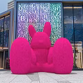 Large Pink Rabbit Sculpture In Front Of Modern Commercial Building With Alphabet Art