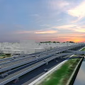 Modern Bridge with Multi Level Roads Urban Buildings Green Spaces and Sunset Sky