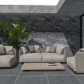 Stylish Outdoor Sofa Patio Setting With Plush Cushions And Green Plants By Stone Wall