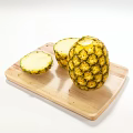 Fresh Whole Pineapple And Sliced Pieces On Wooden Cutting Board
