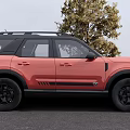 Red SUV With Black Roof And Black Wheels Parked By Tree On Gray Ground