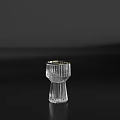 Transparent Wine Bottle And Gold Rimmed Wine Glass With Vertical Stripes On Black Surface