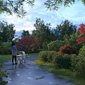 Scenic Evening Park Landscape With Person Pushing Stroller On Wet Path And Colorful Trees