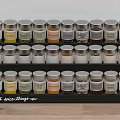 Organized Spice Bottles On Black Rack With Labels For Kitchen Countertop