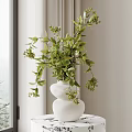 White Stacked Vase With Green Foliage And Small Flowers In Bright Room