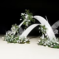 White Curved Wedding Arch With Butterfly Decorations White Flowers And Greenery