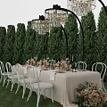 Elegant Dining Table Set With White Chairs Floral Decor Crystal Chandeliers And Green Tree Backdrop