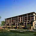 Modern Mid Rise Residential Building With Balconies Stone Wood Elements And Green Garden Area