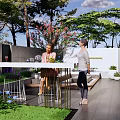 Courtyard Garden Design With Wooden Deck White Sofa Brown Pillows Stone Table And Green Plants