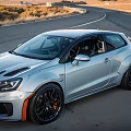 Silver Three Door Sports Car With Black Wheels Orange Brake Calipers On Winding Road