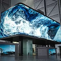 Large LED Screen Showing Dynamic Ocean Wave Visuals With Tall Buildings Background 3d model