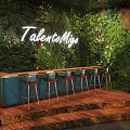 Bar Featuring TalentoMiga Neon Sign Green Plant Wall Wooden Countertop Bar Stools and Wooden Floor