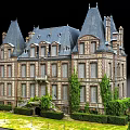 European Building with Steep Roofs Ornate Facades Arched Windows Green Lawn and Trimmed Shrubs