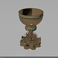 Ornate Golden Cup With Green Gemstone Embellishments And Intricate Pedestal Base
