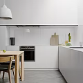 Minimalist Modern Kitchen Interior With White Cabinets Walls Pendant Light Wooden Table And Green Fruits