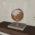 Decorative Globe on Wooden Tabletop With Beige Base and Small Green Plant