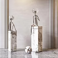 Abstract Metal Sculptures with Seated Human Figures on Marble Pedestals and White Decorative Ball