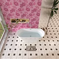 White Bathtub in Bathroom With Pink Floral Wallpaper and Black White Checkered Floor Tiles