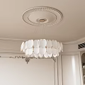 Elegant White Chandelier with Petal Design Hanging In Room With Decorative Ceiling And Wall Moldings