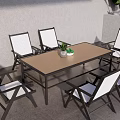 Outdoor Black Frame Dining Set With White Cushioned Chairs Brown Tabletop And Small Potted Plant