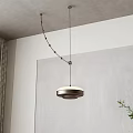 Modern Circular Pendant Light Hanging From Gray Ceiling With White Wall Curtain And Green Plant