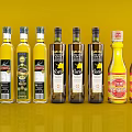 Various Types Of Condiment Bottles Arranged On Yellow Background With Labels