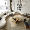 Curved White Sofa with Pillows Round Wooden Coffee Table and Rug in Modern Living Room