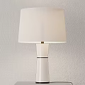 Modern Illuminated Table Lamp With White Lampshade On Gray Cubic Base Against Light Wall Background