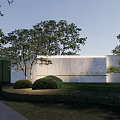 Modern Landscape Wall With White Stone Material Green Plants Trees Shrubs And Soft Lighting
