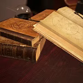 Open Vintage Book With Yellowed Pages Legends Text Key And Feather Quill On Wooden Table