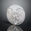 Silver Round Jewelry Piece With Elephant Carving Intricate Design And Shiny Surface On Dark Background