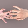 Woman's gentle hands reaching out softly towards each other on gray background