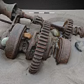 Scenic Landscape Featuring Rusted Metal Gears and Machinery Parts on Sandy Ground with Stones