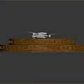White Drone Placed On Brown Circular Stepped Structure With Layered Design