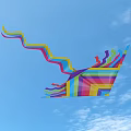 Colorful Striped Kite Flying High In Blue Sky With White Clouds