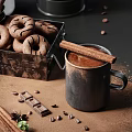 Glass French Press Coffee Maker with Chocolate Sticks Donuts and Cinnamon Sticks in Metal Container
