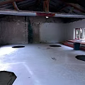 Unfinished Building Interior With Wooden Beams Damaged Walls Windows And Circular Floor Depressions