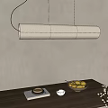 Natural Woven Long Pendant Light Over Wooden Table With Lemons Flower Branch And Books