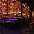 Stylish Bar Interior With Rows Of Colorful Bottles Illuminated Counter And Cozy Seats