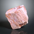 Pink Layered Stone With Wood Like Grain Texture In Irregular Block On Dark Reflective Background