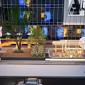 Bustling Modern Commercial Street With Glass Facades Pedestrians Green Plants And Art Sculptures