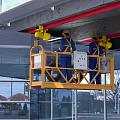 Urban Building Complex With Workers On Aerial Platform And Modern Glass Curtain Walls