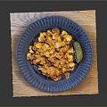 Hearty Orange Savory Dish on Blue Plate with Pickle and Wooden Board