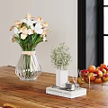 Transparent Vase With White Pink Flowers On Wooden Table With Green Plant And Fruit Bowl