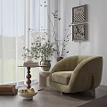 Modern Light Green Armchair with Small Round Table Books Vase Wall Art and Curtains in Cozy Setting