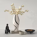 White And Black Curved Vase With White Floral Arrangement On Table With Statue And Books