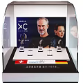 Transparent Display Shelf Showcasing Headphones With Screen Portraits And Swiss Price Information