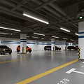 Modern Parking Garage With Yellow White Arrow Markings White Columns Blue Stripes And Parked Cars