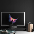 Modern Television Displaying Vibrant Butterfly with Purple Pink Wings on Black Base and Wooden Cabinet